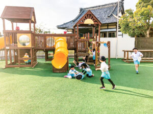 幼稚園の人工芝で遊ぶ園児たち