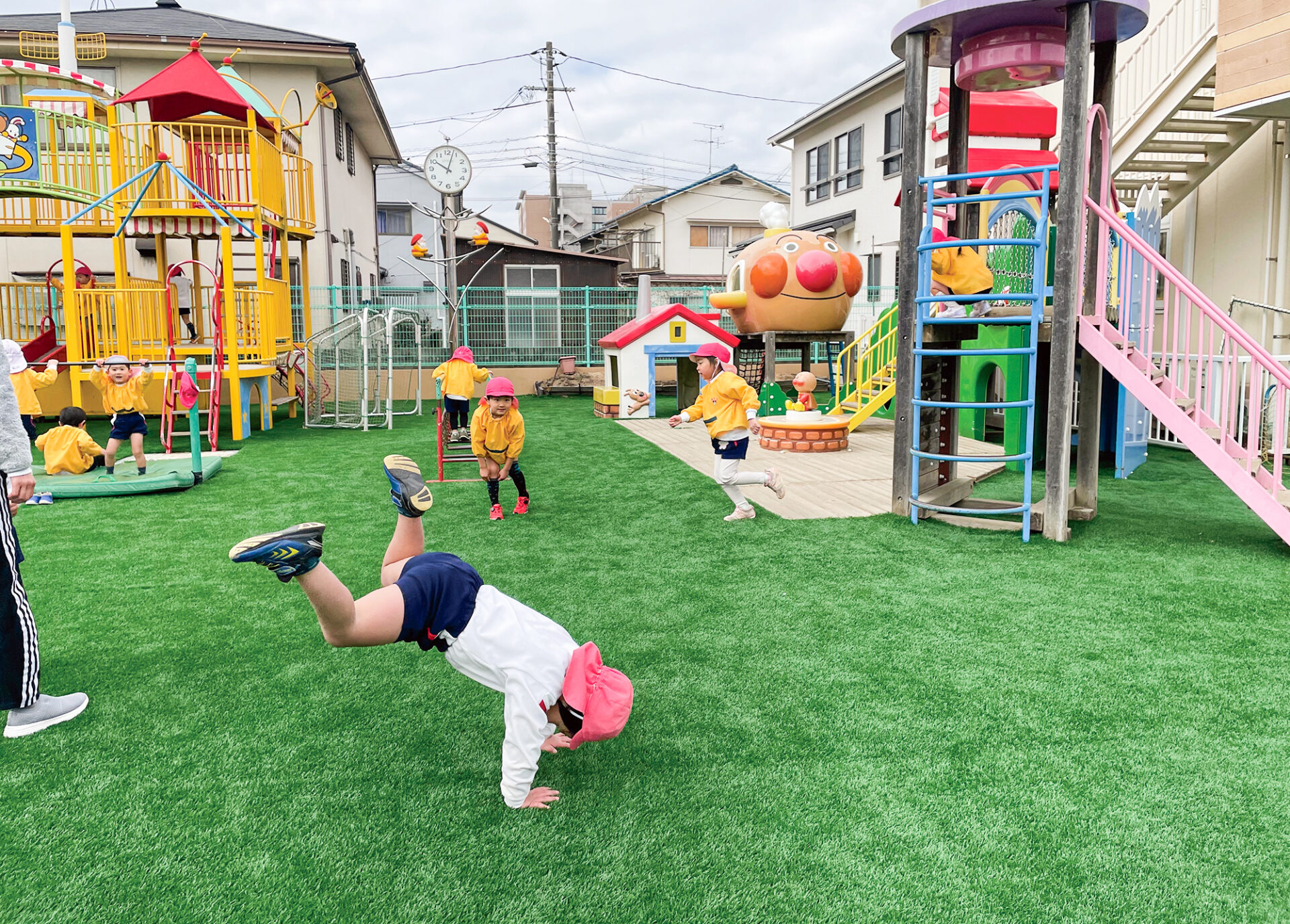 人工芝の園庭で思い切り遊ぶ園児たち