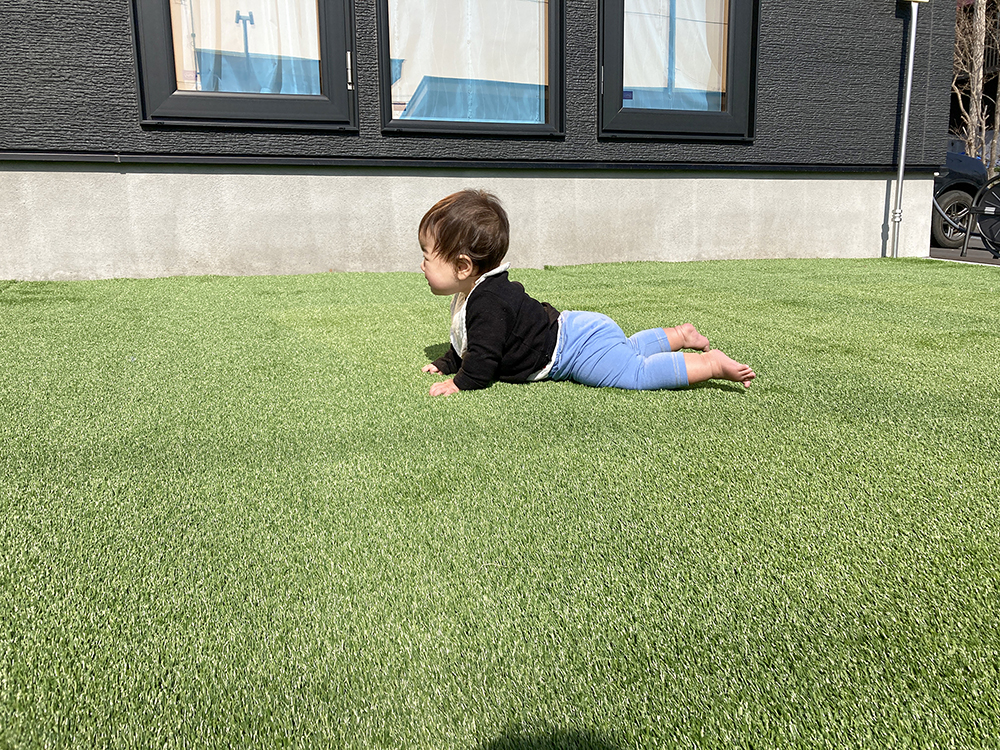 人工芝の上に転がる赤ちゃん
