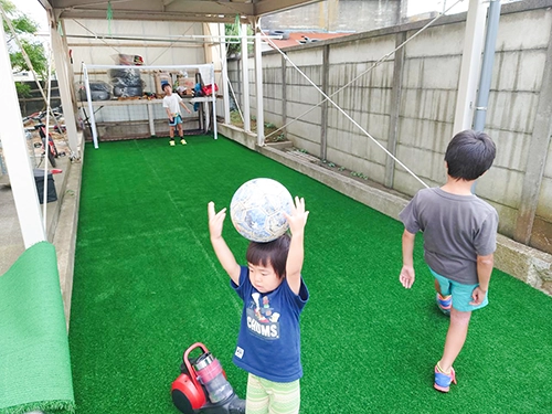 サッカーゴールのあるお庭で遊ぶ子どもたち