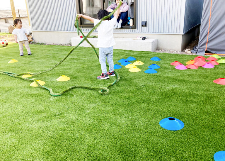 人工芝のお庭で遊ぶ親子