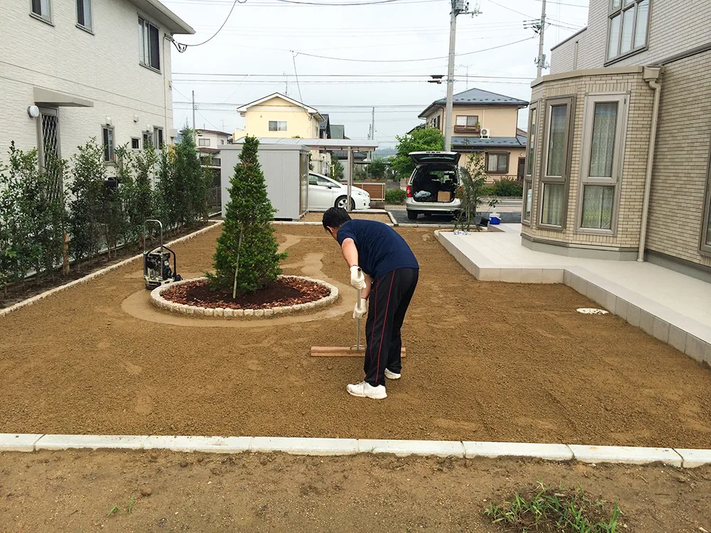 庭の土をならす