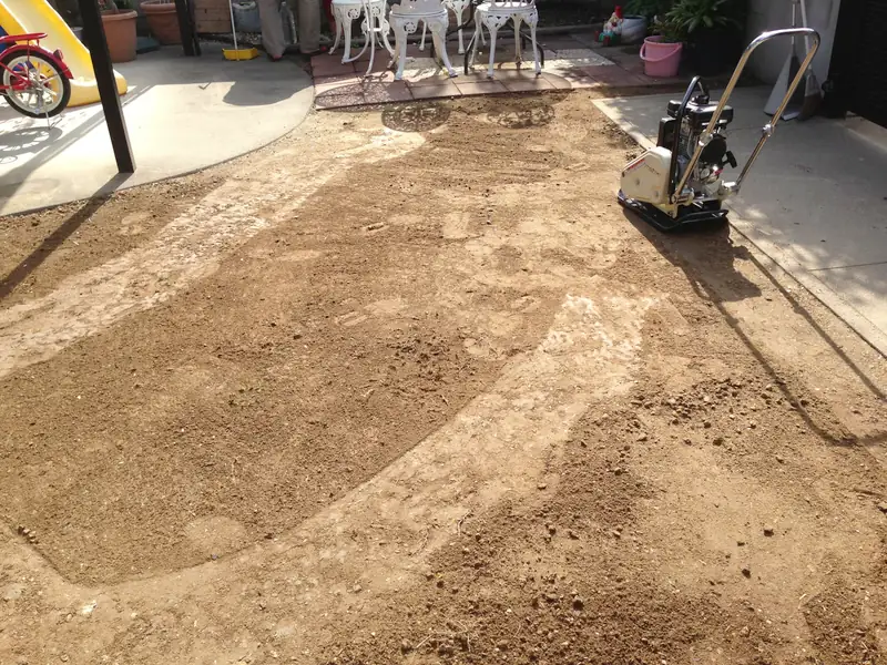 転圧機をかけた跡が帯になって残る庭の土