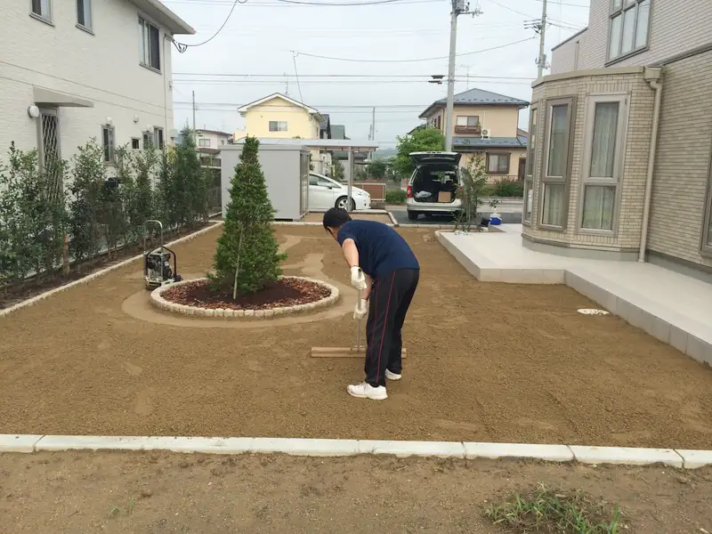 トンボで庭の土をならす